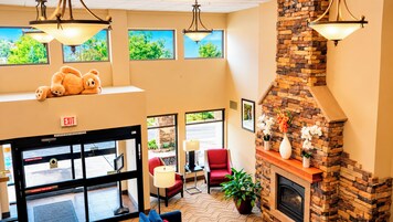 Un hall con chimenea, zona de estar y un oso de peluche en un estante.
