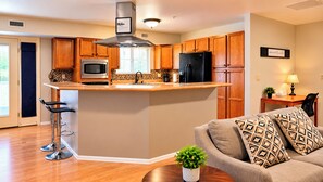 A modern kitchen with wooden cabinets, stainless steel appliances, and a central island. - Manitou Pikes Peak Hotel (Manitou Springs)