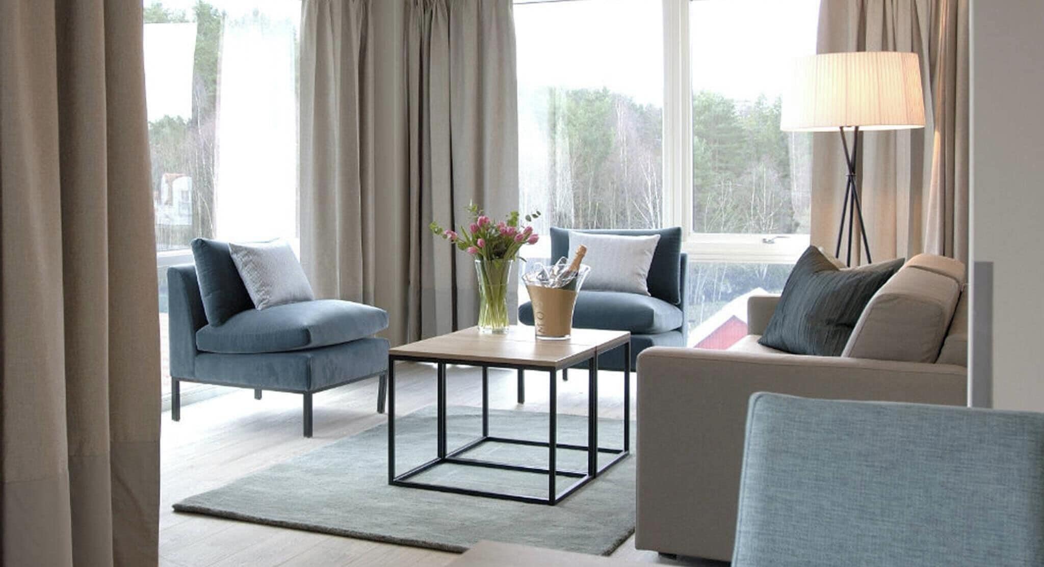 Un salon moderne avec deux canapés, une table basse et un lampadaire.