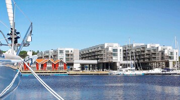 Una marina con barcos, un edificio rojo y modernos edificios de apartamentos al fondo.