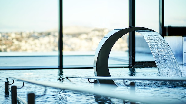 A modern indoor pool with a clear view of the cityscape through large windows.