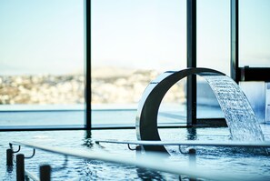 A modern indoor pool with a clear view of the cityscape through large windows.