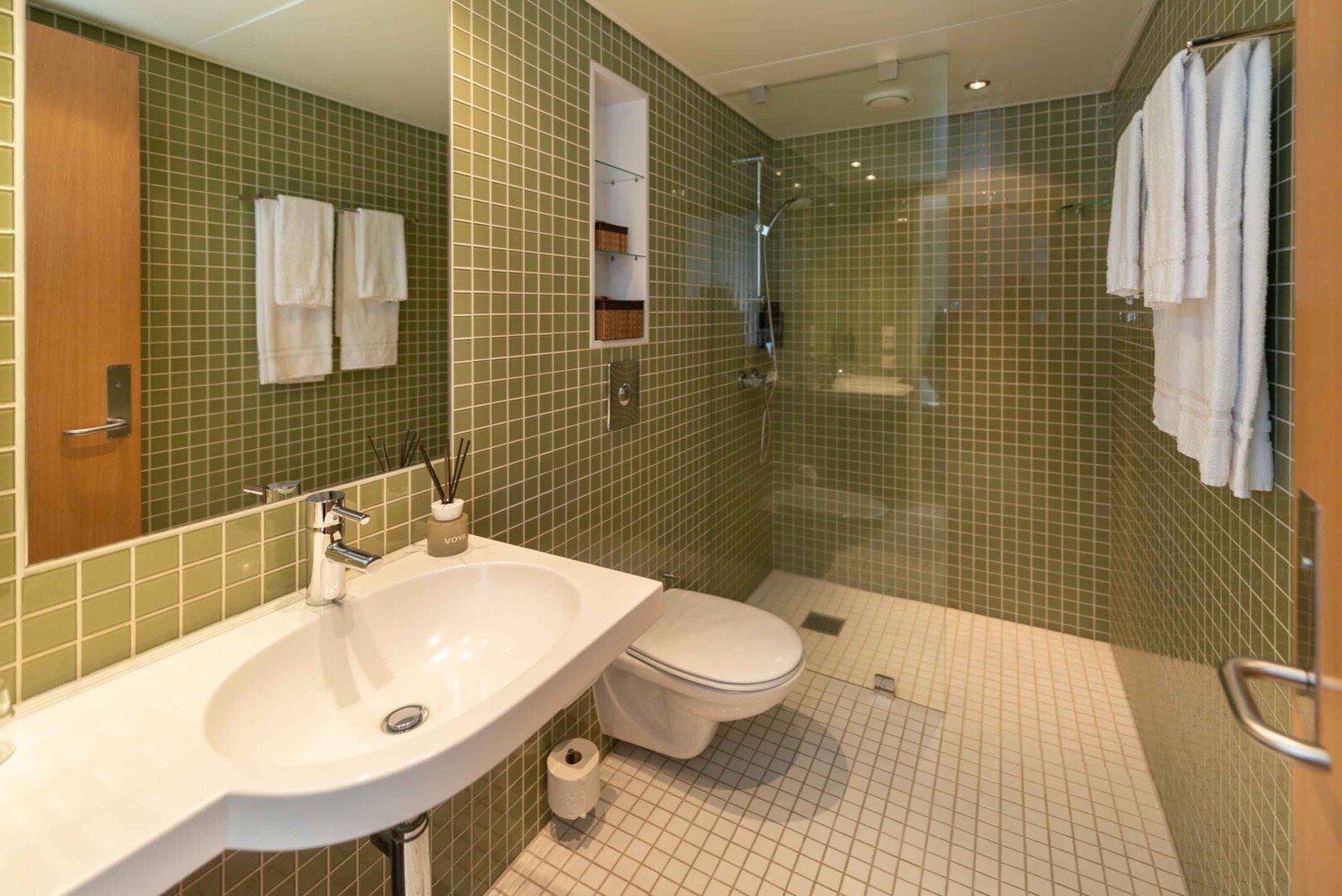 A bathroom with a sink, toilet, and shower.