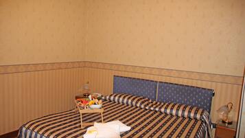 A hotel room with a bed, a bedside table, and a nightstand.