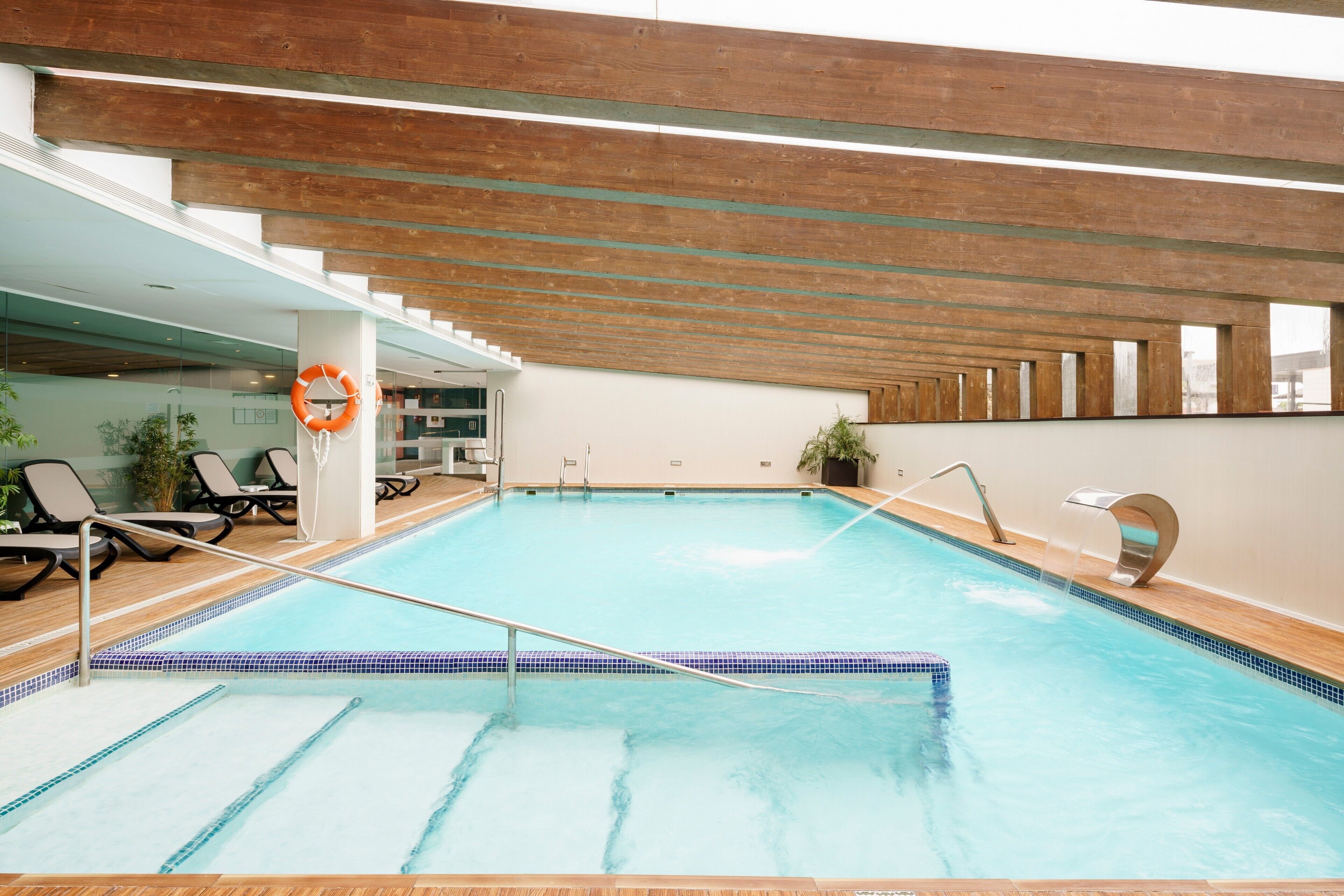 Una piscina cubierta, una piscina al aire libre de temporada, sombrillas