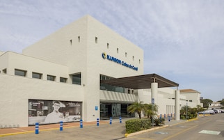 Un hotel moderno con una entrada destacada y un área techada.