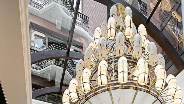 Una gran escalera con barandillas ornamentales que conduce a un atrio de varios niveles.