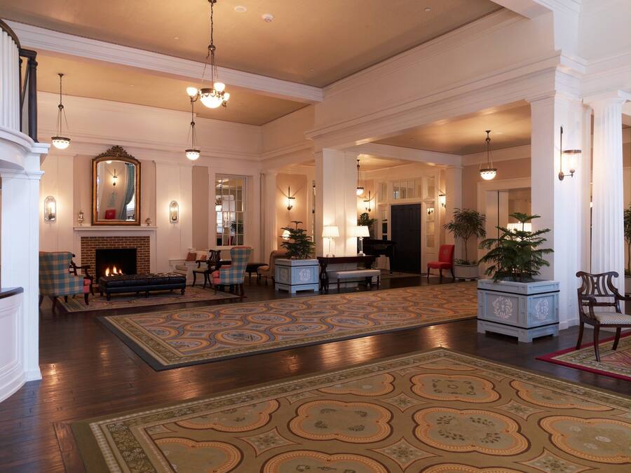 A spacious lobby with a fireplace, seating area, and a grand piano.