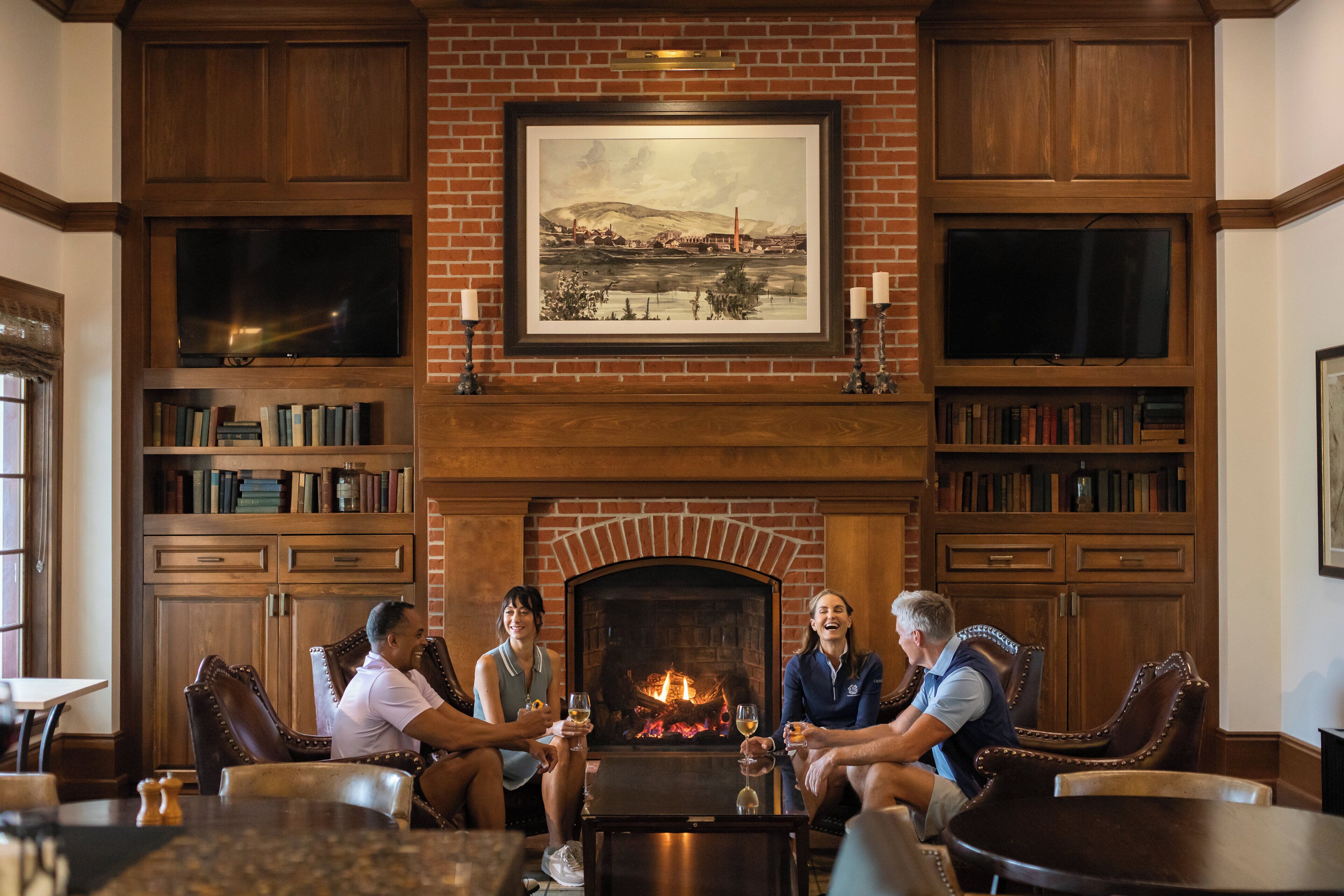 A cozy room with a fireplace, bookshelves, and comfortable seating.