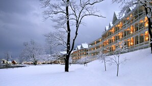 Un hôtel enneigé, doté de nombreux balcons et d’une grande façade.