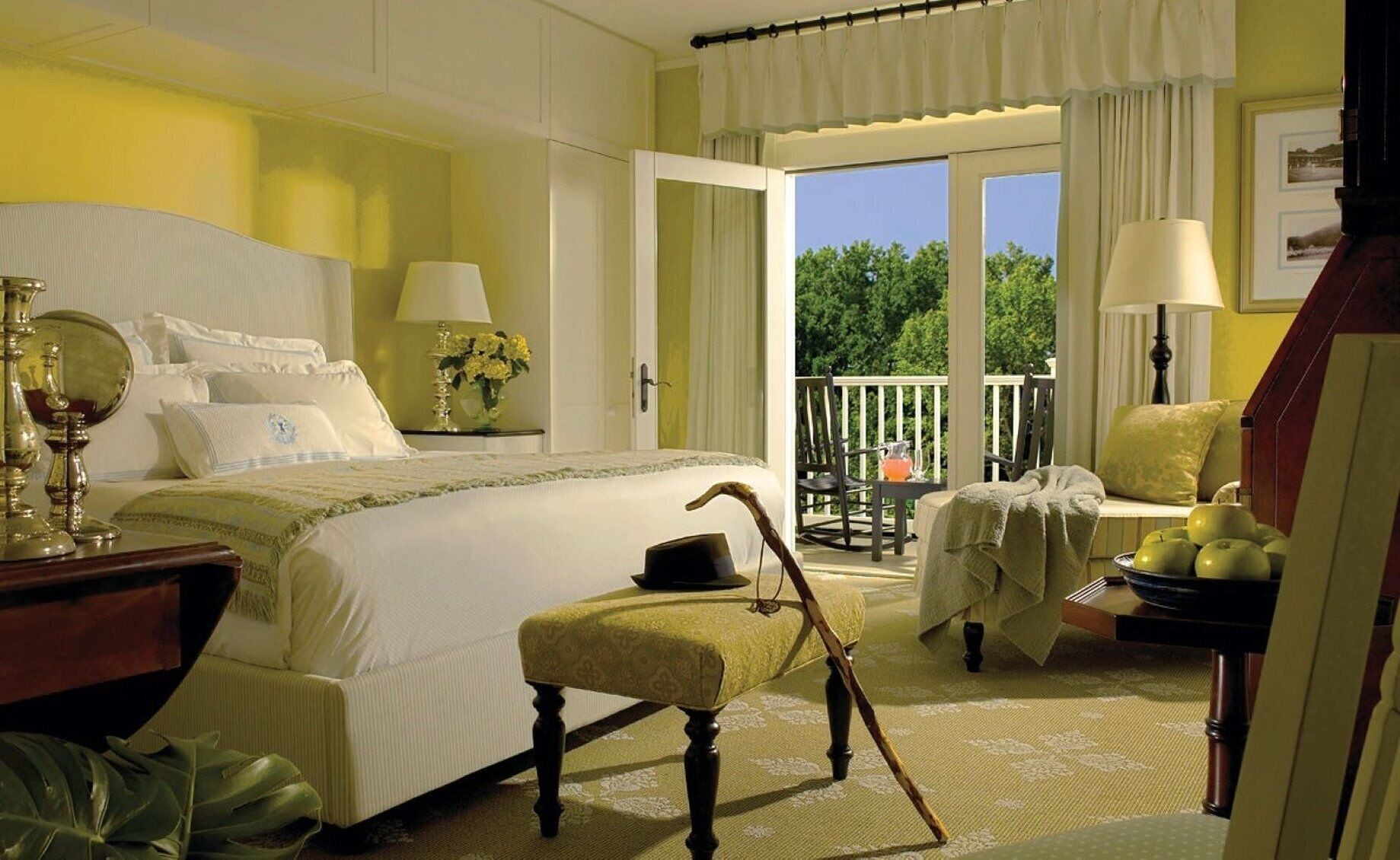 Une chambre à coucher avec un lit, une table de chevet, une lampe et une vue sur l’extérieur.