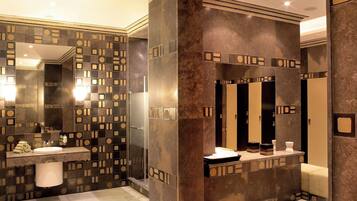 Un baño moderno con un espejo grande, un lavamanos y una zona de ducha.