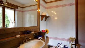 A bathroom with a wooden vanity, a large mirror, and a sink.