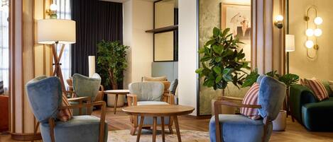 Een moderne lounge met zitgedeelte, een ronde tafel en decoratieve verlichting.
