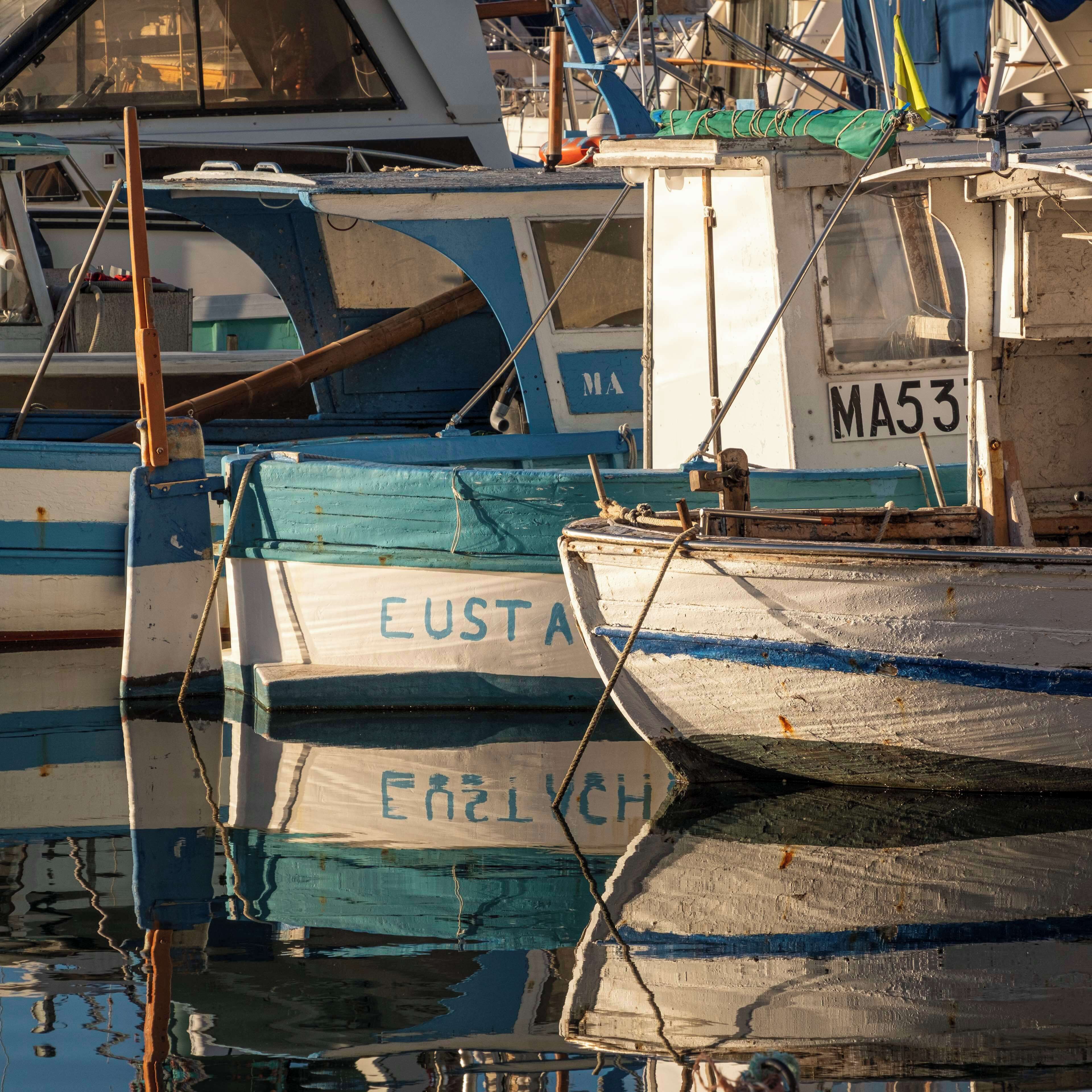 Un puerto deportivo con varias embarcaciones amarradas, incluyendo una con el nombre 'EUSTA' y otra con 'EARLCH'.