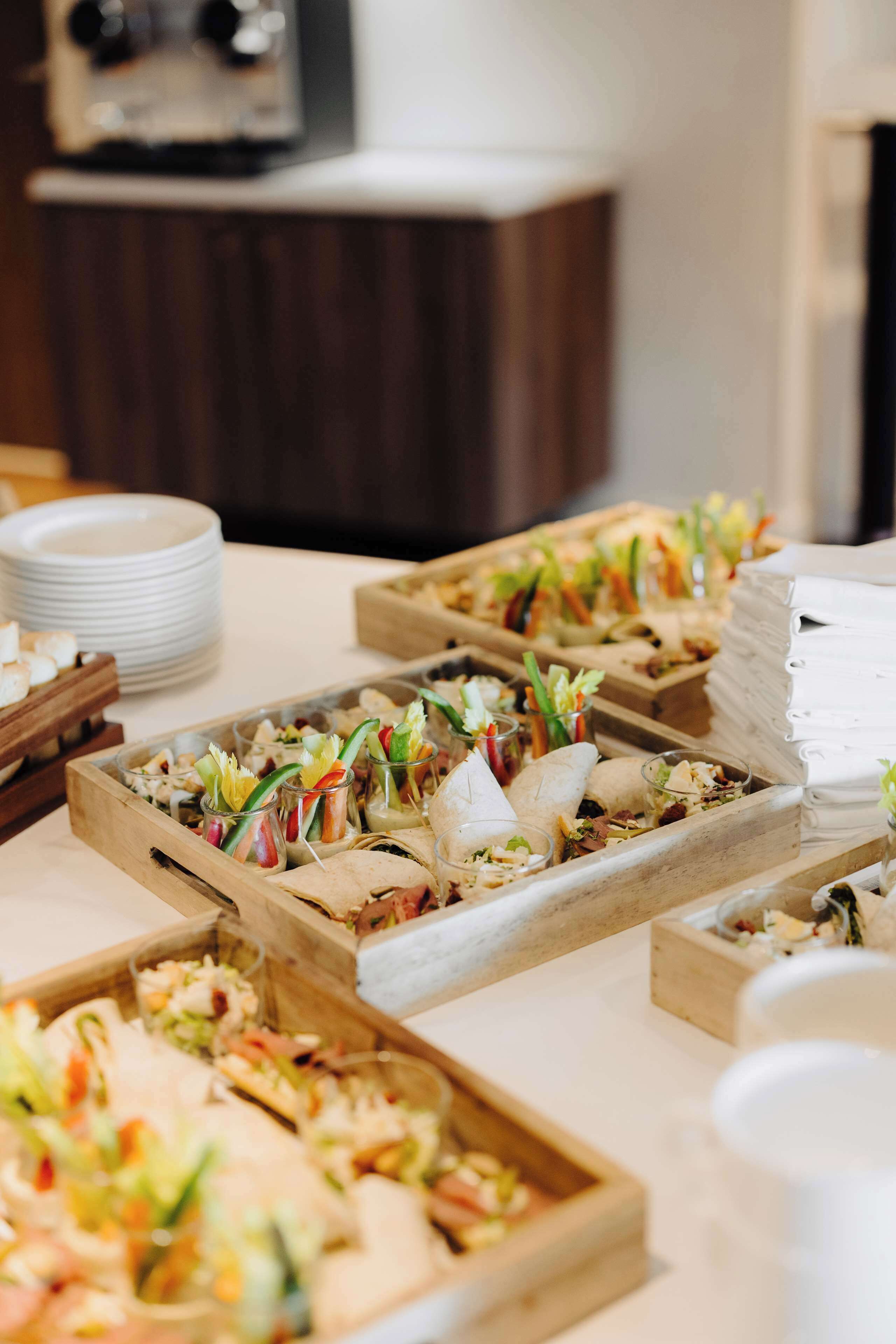 A buffet table with various food items and clear glass containers.