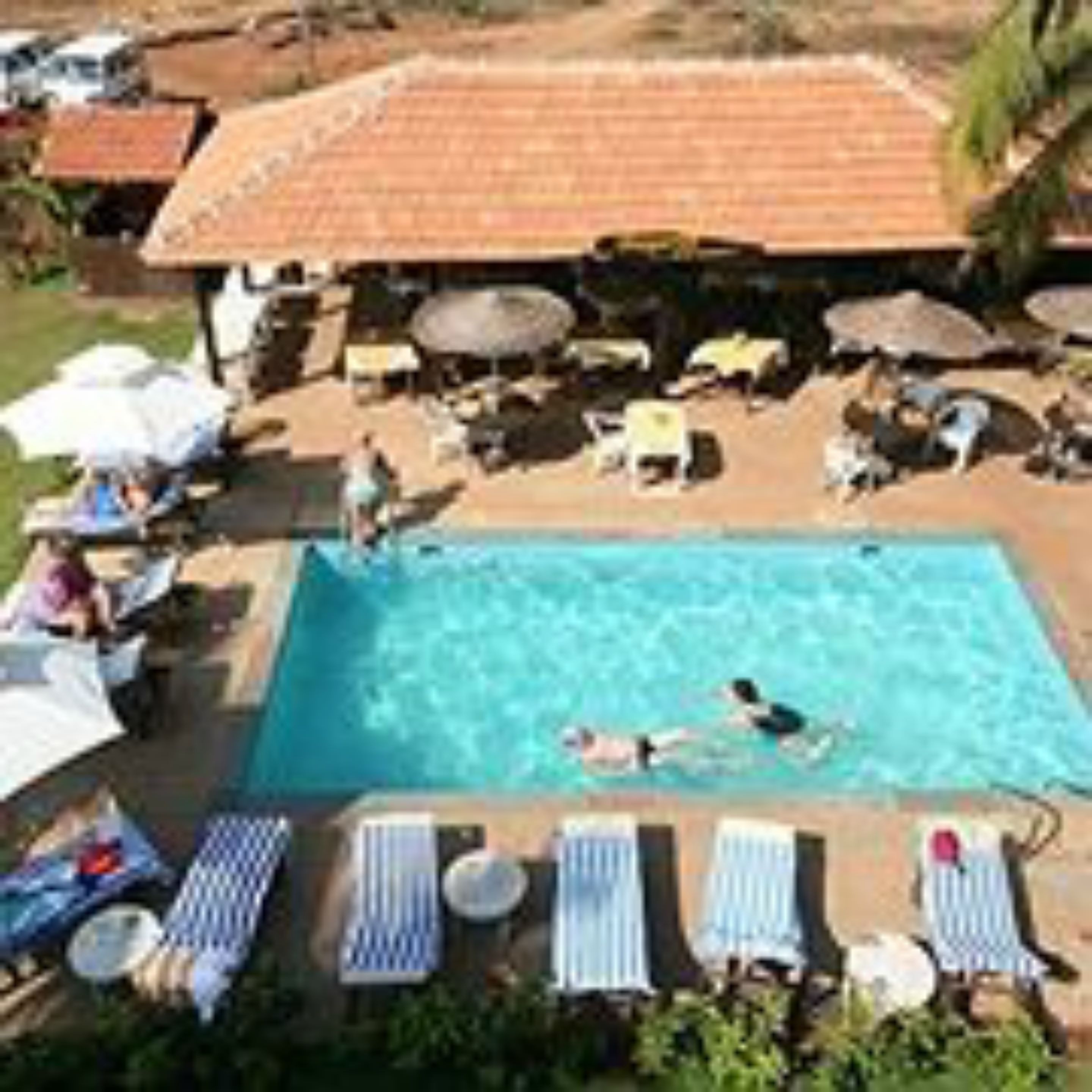 A swimming pool with lounge chairs and umbrellas.