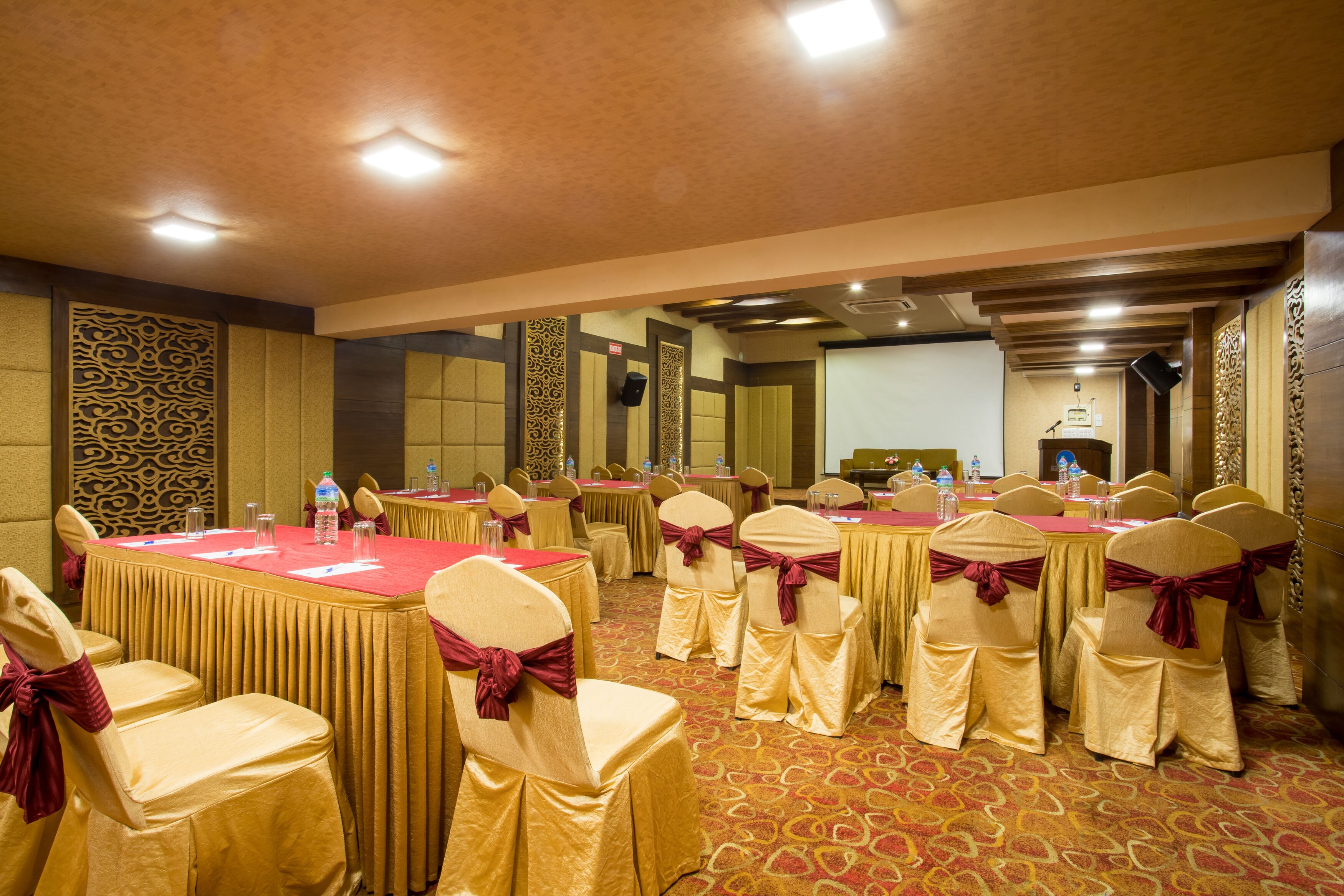 A conference room with tables, chairs, and a podium.
