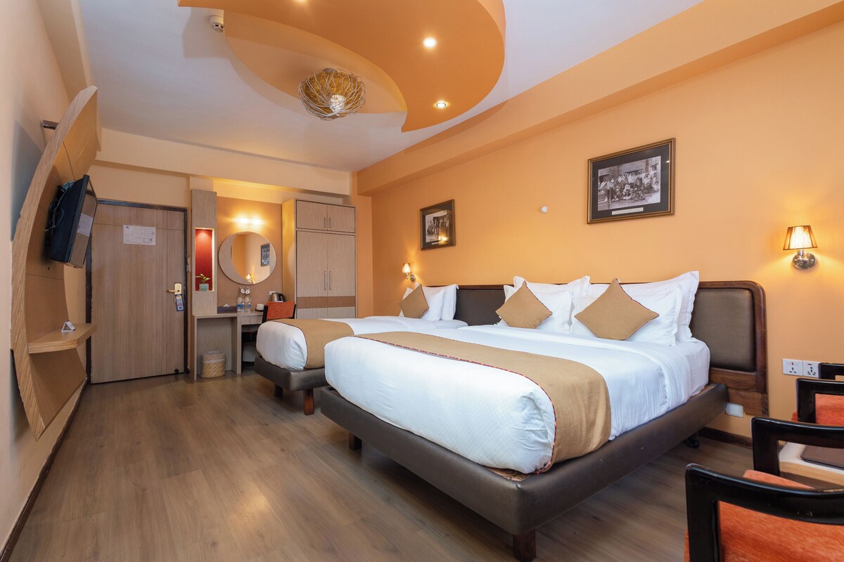 Ein Hotelzimmer mit einem großen Bett, einem Schreibtisch, einem Stuhl und einem Kleiderschrank.
