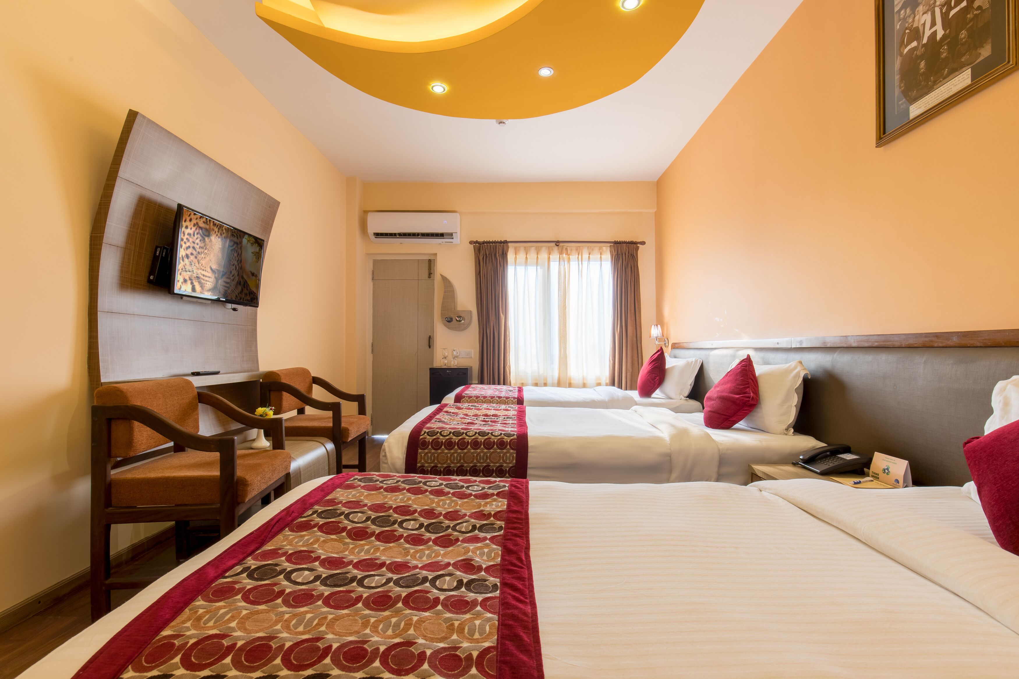 Habitación de hotel con dos camas, televisión, escritorio y una silla.