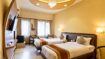 A hotel room with two beds, a TV, a desk, and a chair.