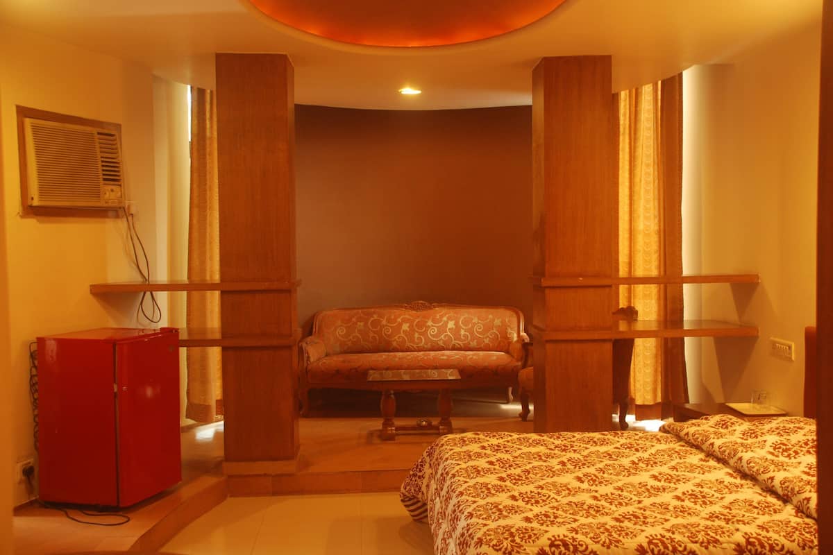 Ein Hotelzimmer mit einem Bett, einer Couch, einem kleinen Tisch und einem roten Schrank.