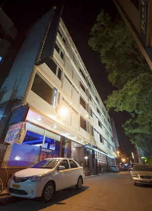 A multi-story hotel with a ground-floor bar and a car parked in front. - Hotel Regent Continental (New Delhi)
