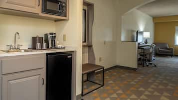 A compact kitchenette with a microwave, coffee maker, and a dishwasher.