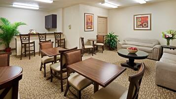 A hotel lobby with a dining area, a sofa, and a coffee table.