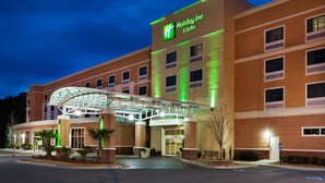 Un hotel Holiday Inn & Suites con entrada de vidrio y fachada de ladrillo.