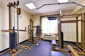 A gym with various exercise equipment, a bench, and a window with curtains. - Holiday Inn Express Hotel and Suites Las Cruces by IHG (Las Cruces)