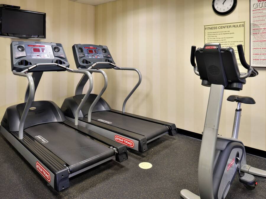 Una palestra attrezzata con tapis roulant, una cyclette e uno schermo a parete.