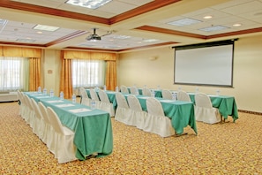 A conference room with long tables, chairs, and a projector screen. - Holiday Inn Express Hotel and Suites Las Cruces by IHG (Las Cruces)