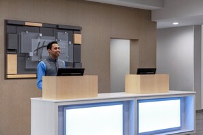 A reception desk with two computer stations, a modern wall design, and a neutral color palette. - Holiday Inn Express Dumfries by IHG (Dumfries)