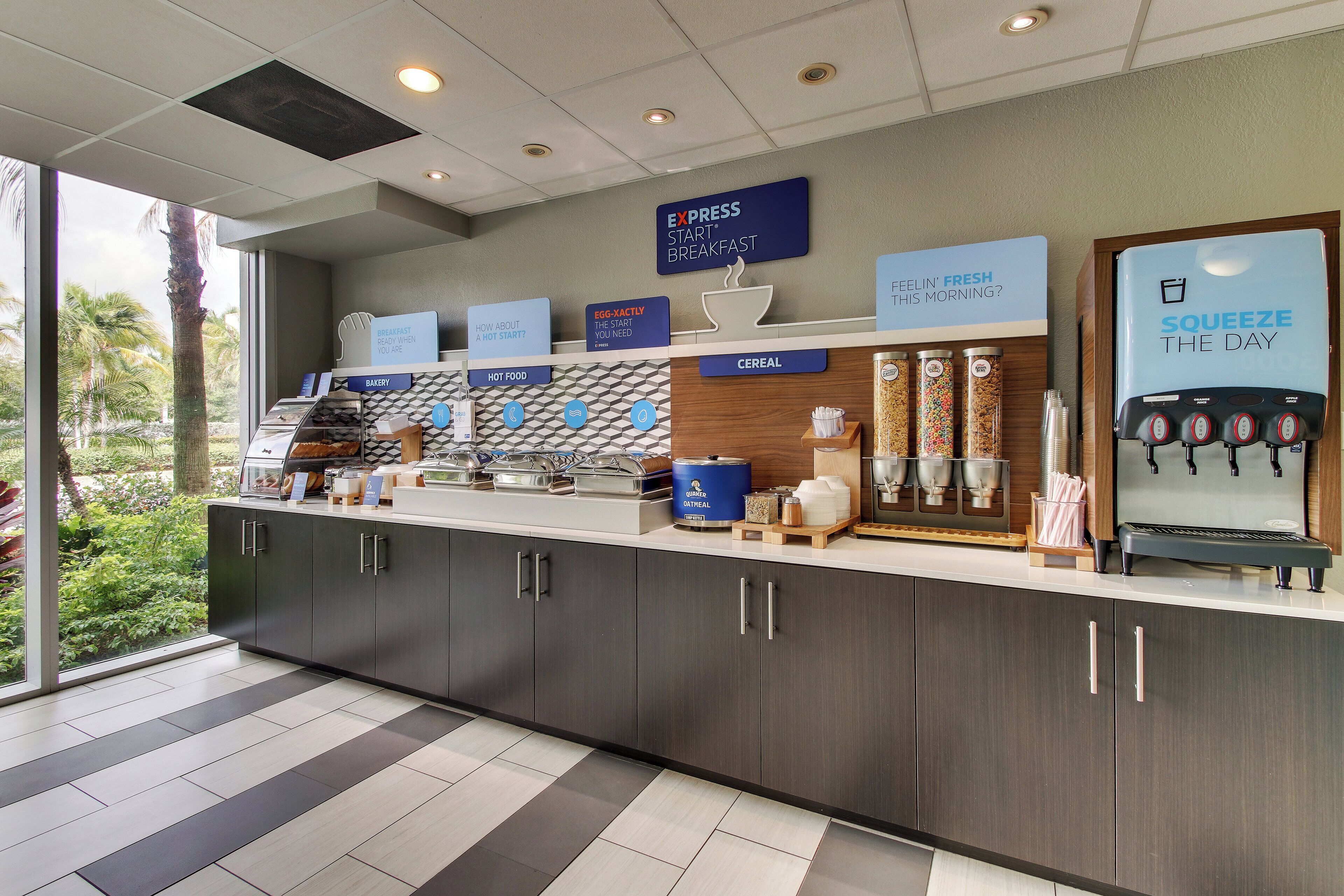 A breakfast bar with various food options and a sign that reads 'SQUEEZE THE DAY'.