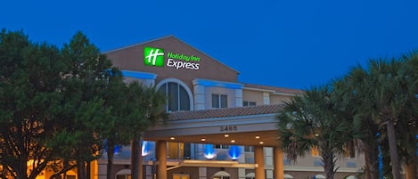 A Holiday Inn Express building with a prominent 'HH' logo, a covered entrance, and a number '2485' on the facade.