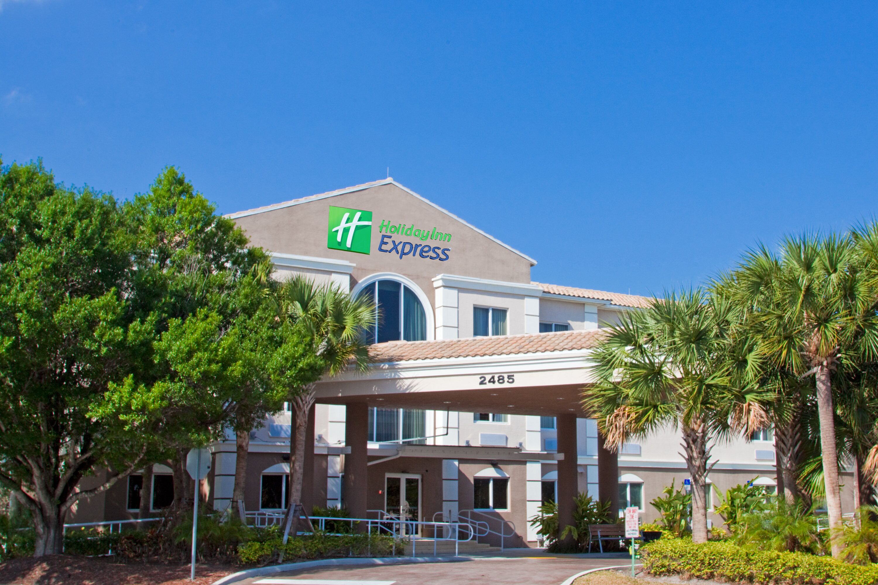 Edifício do Holiday Inn Express com telhado plano, grandes janelas e uma placa com o nome do hotel.