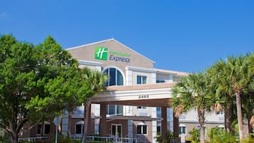 Edifício do Holiday Inn Express com telhado plano, grandes janelas e uma placa com o nome do hotel.