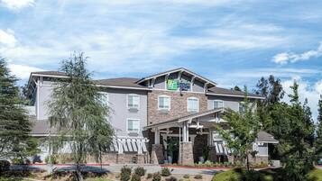 Een meerlaags hotel met een gevel van steen, een overdekte ingang en een bord waarop staat dat het een Holiday Inn Express is.