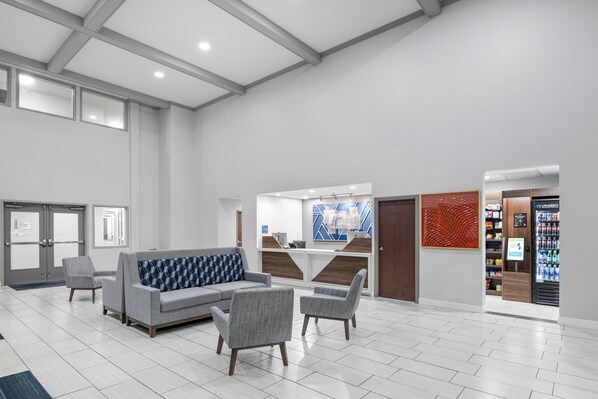 A spacious lobby with a reception desk, seating area, and vending machine. - Holiday Inn Express Hotel & Suites San Dimas by IHG (San Dimas)