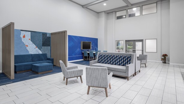 A spacious lobby with a blue and white color scheme, a large map on the wall, and a seating area with sofas and chairs. - Holiday Inn Express Hotel & Suites San Dimas by IHG (San Dimas)