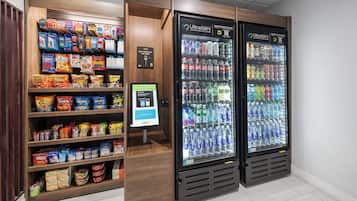 A self-checkout kiosk and vending machines with snacks and drinks.