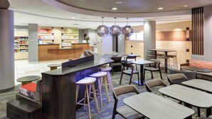 A modern hotel lobby with a reception desk, bar area, and seating arrangements including tables and bar stools. - SpringHill Suites by Marriott Portland Vancouver (Vancouver)