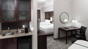 A hotel room with a kitchenette, a bed, a desk with a chair, a round mirror, and a small table. - SpringHill Suites by Marriott Portland Vancouver (Vancouver)