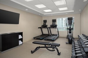 A fitness room with treadmills, a bench, dumbbells, and a TV screen. - SpringHill Suites by Marriott Portland Vancouver (Vancouver)