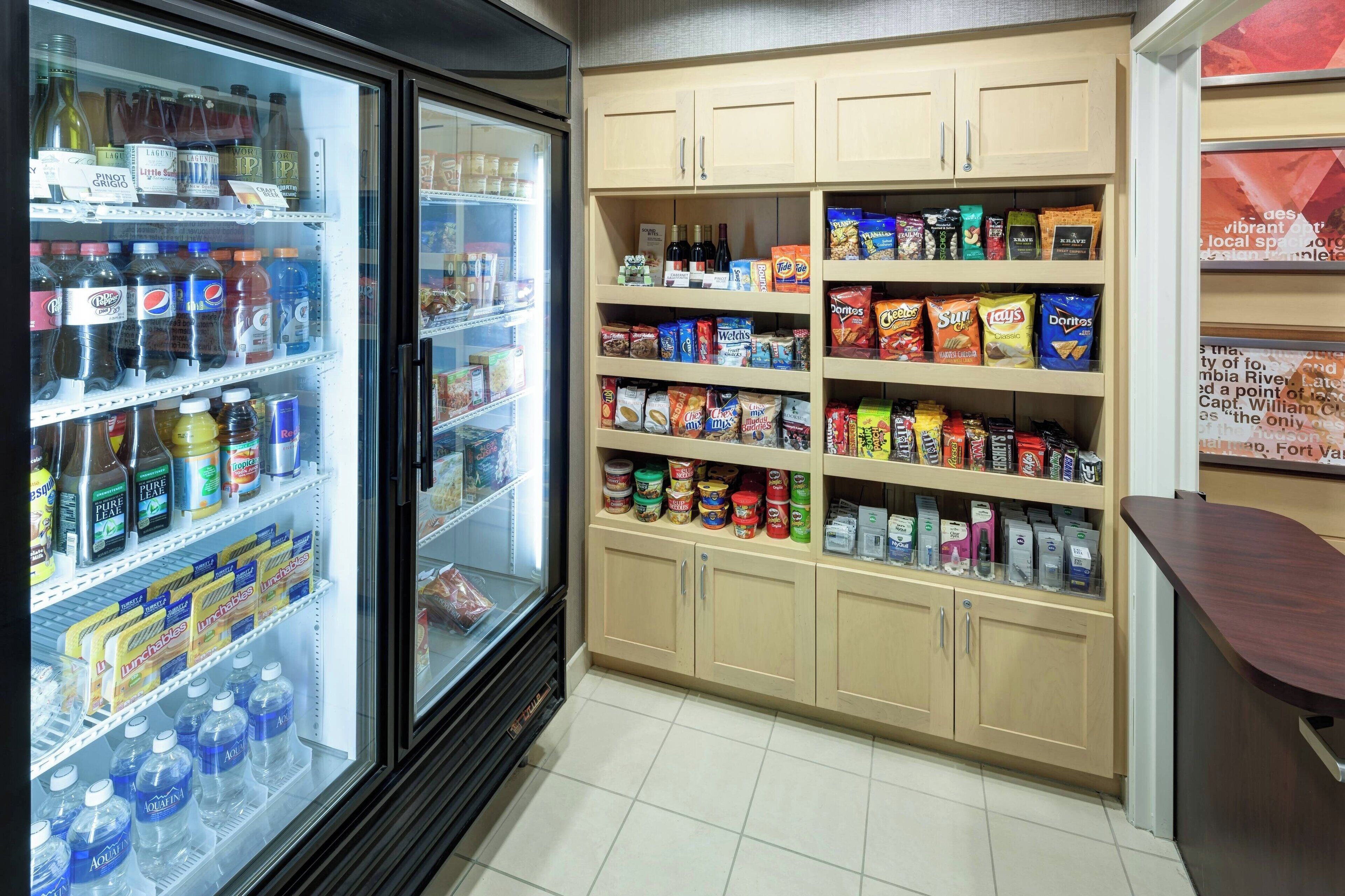 A refrigerated beverage cooler stocked with various drinks and a pantry with snacks and beverages.