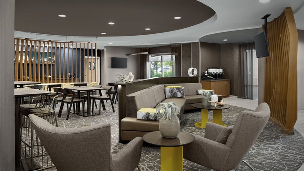 A modern hotel lobby with a seating area, a coffee station, and a TV mounted on the wall. - SpringHill Suites by Marriott Portland Vancouver (Vancouver)