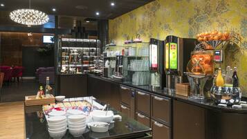 A breakfast bar with various food items and a coffee machine.