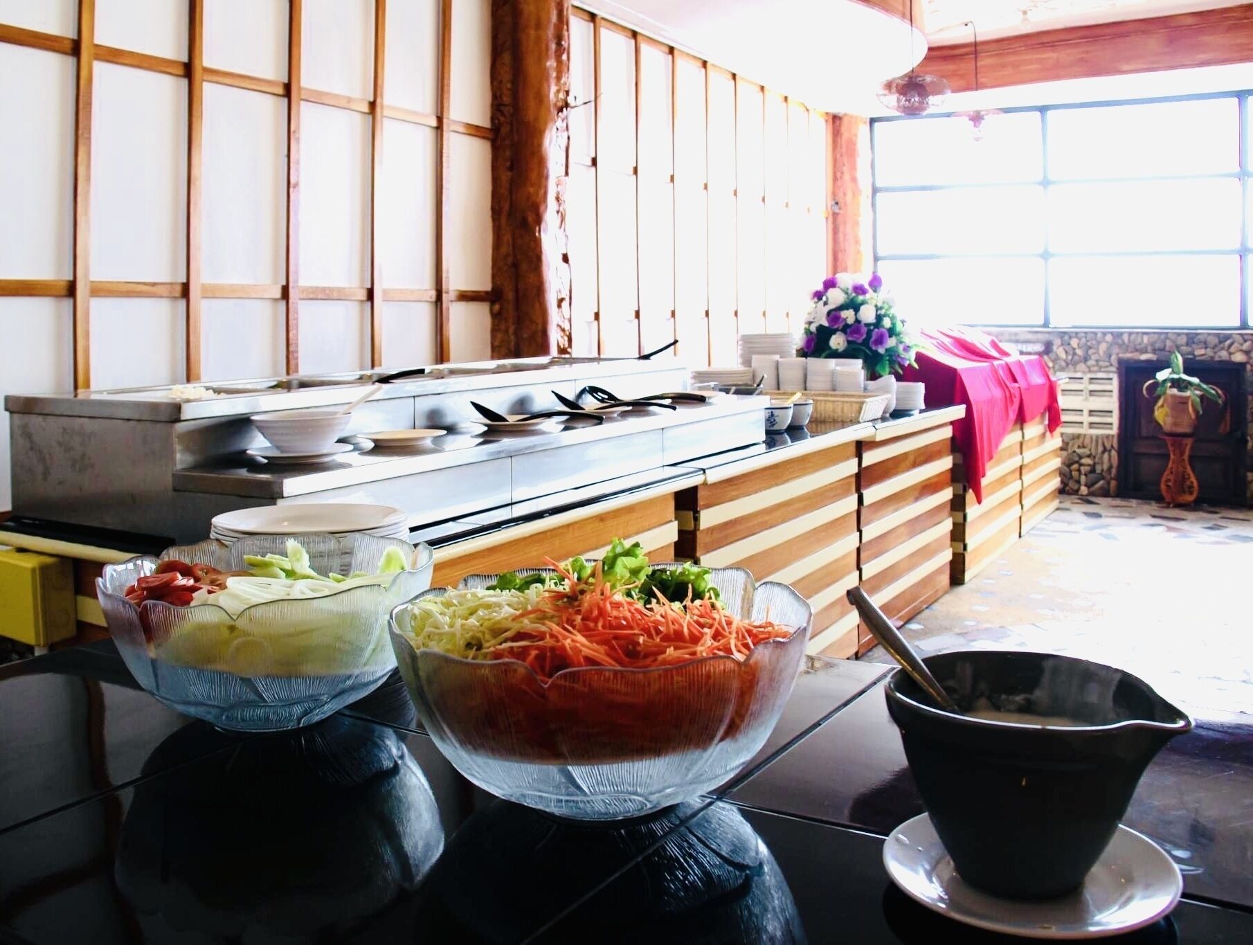 A kitchen with a stove, a buffet table with various food items, and a potted plant.