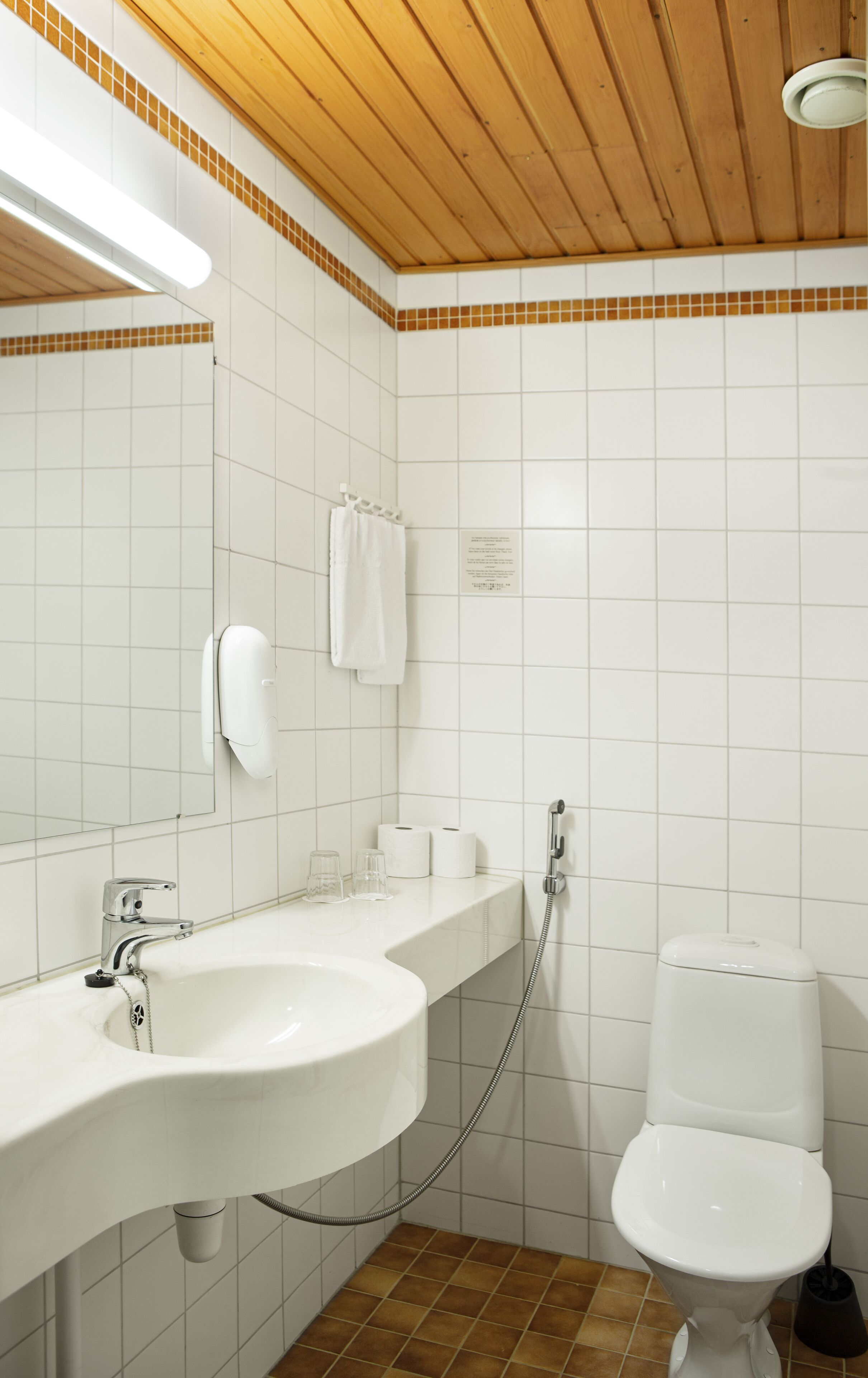A bathroom with a white sink, a mirror, a toilet, and a shower.